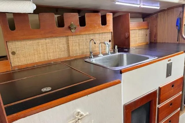 Slide: The Image of 1965 Pearson Alberg 35 yacht interior kitchen with sink and wooden cabinetry. - 8