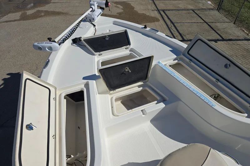 Slide: The Image of 2017 NauticStar 215 XTS boat deck with open storage compartments and trolling motor. - 14