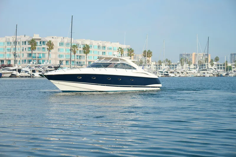 Slide: The Image of Sunseeker Camargue 50 yacht cruising in marina, 2000 model, with waterfront buildings in background. - 2