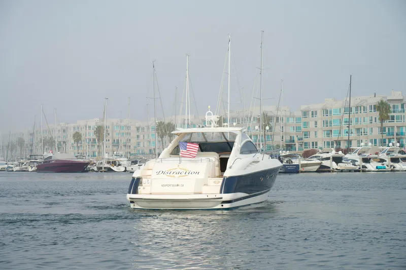 Slide: The Image of Sunseeker Camargue 50 yacht, 2000 model, cruising in a marina with modern buildings. - 5