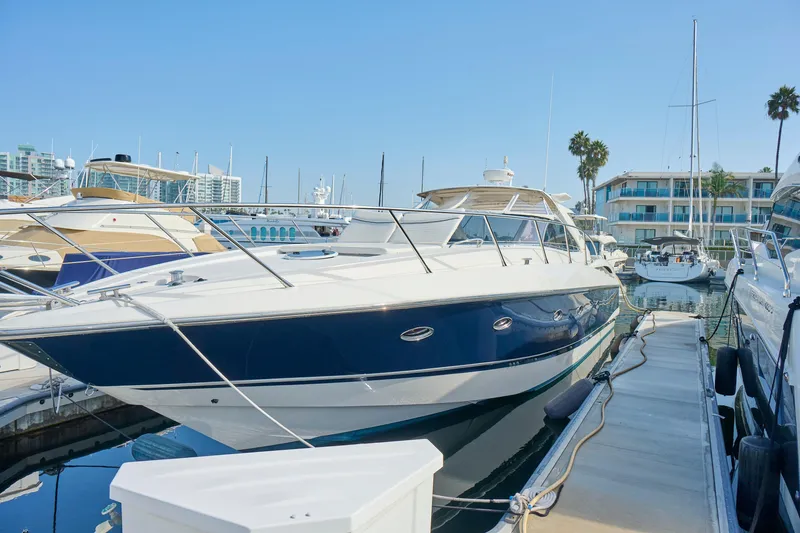 Slide: The Image of Sunseeker Camargue 50 yacht, 2000 model, docked at a marina under clear blue skies. - 50