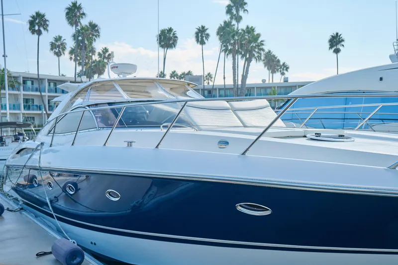 Slide: The Image of Sunseeker Camargue 50 yacht, 2000 model, docked with palm trees in the background. - 52