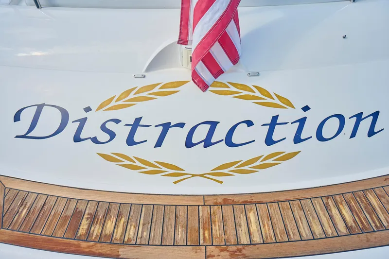 Slide: The Image of Sunseeker Camargue 50 yacht named "Distraction" with decorative lettering and flag. - 53