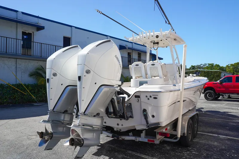Slide: The Image of 2021 Blue Wave Boats Makaira with dual outboard motors on a trailer. - 4