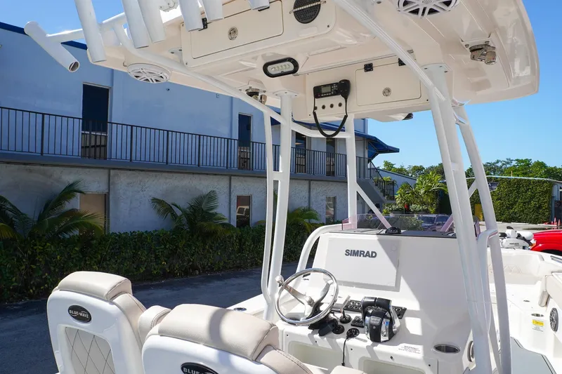 Slide: The Image of 2021 Blue Wave Boats Makaira interior with steering console and Simrad electronics. - 7