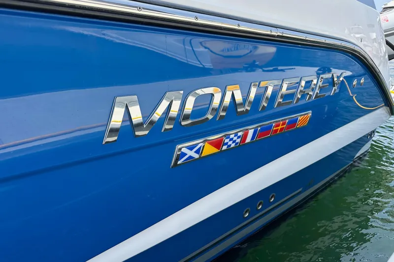 Slide: The Image of 2020 Monterey 355 Sport Yacht with nautical flags on blue hull. - 13