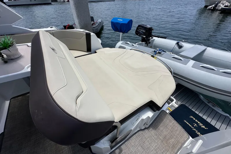 Slide: The Image of 2020 Monterey 355 Sport Yacht with seating area and inflatable boat at dock. - 18