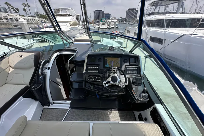 Slide: The Image of 2020 Monterey 355 Sport Yacht helm with modern controls and marina view. - 27
