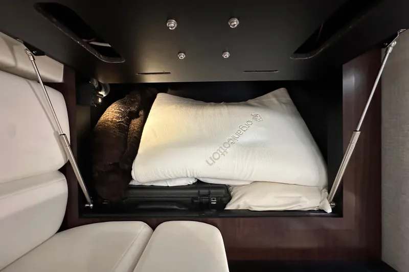 Slide: The Image of Under-seat storage in 2020 Monterey 355 Sport Yacht with pillows and blanket. - 55
