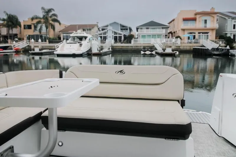 Slide: The Image of 2020 Monterey 355 Sport Yacht interior with seating and table, docked in a marina. - 65