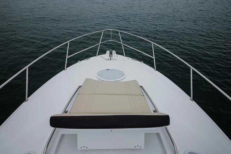 Slide: The Image of Monterey 355 Sport Yacht 2020 bow view with sun pad, on calm water. - 66