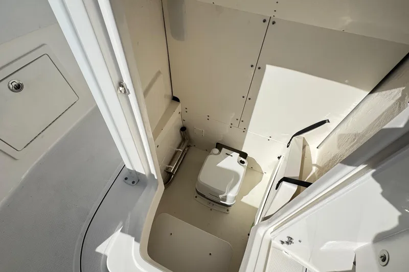 Slide: The Image of 2026 Robalo R230 Center Console boat interior with compact marine toilet. - 13