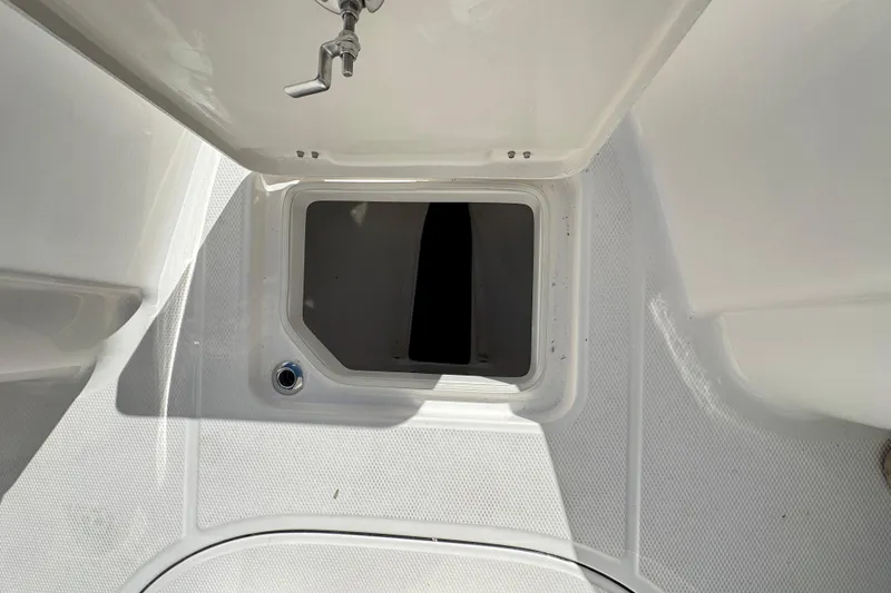 Slide: The Image of 2026 Robalo R230 Center Console storage compartment, open hatch view. - 19