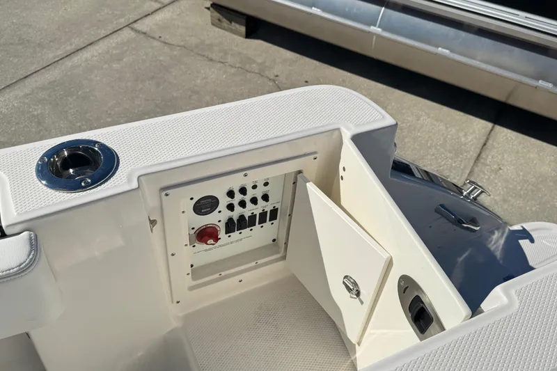 Slide: The Image of 2026 Robalo R230 Center Console boat control panel with open access door. - 9