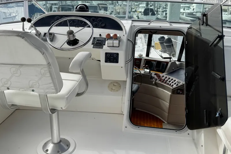 Slide: The Image of 1998 Bayliner 4788 Pilot House Motoryacht stern with swim platform reflected in calm water. - 13