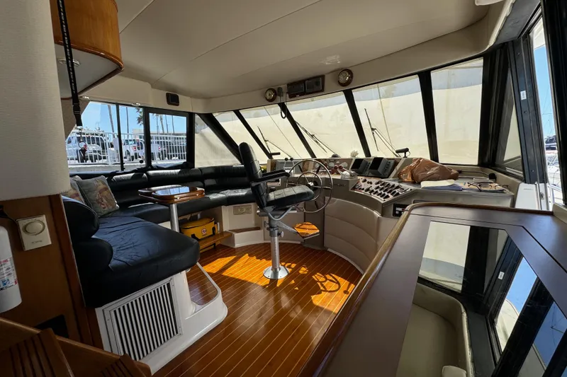 Slide: The Image of 1998 Bayliner 4788 Pilot House Motoryacht interior with control panel and wooden flooring. - 36