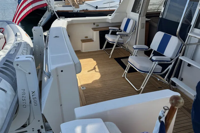 Slide: The Image of 1998 Bayliner 4788 Pilot House Motoryacht deck with seating and American flag. - 5