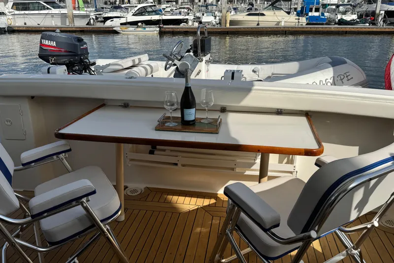 Slide: The Image of 1998 Bayliner 4788 Pilot House Motoryacht deck with seating, table, and marina view. - 9