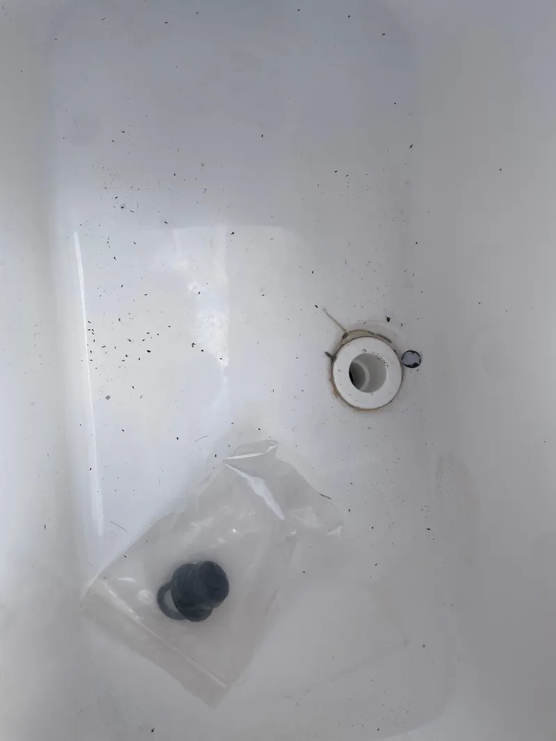 Slide: The Image of 2024 NauticStar 191H boat interior with drain plug and debris. - 11