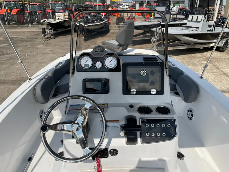 Slide: The Image of 2024 NauticStar 191H boat dashboard with steering wheel, gauges, and navigation system. - 13