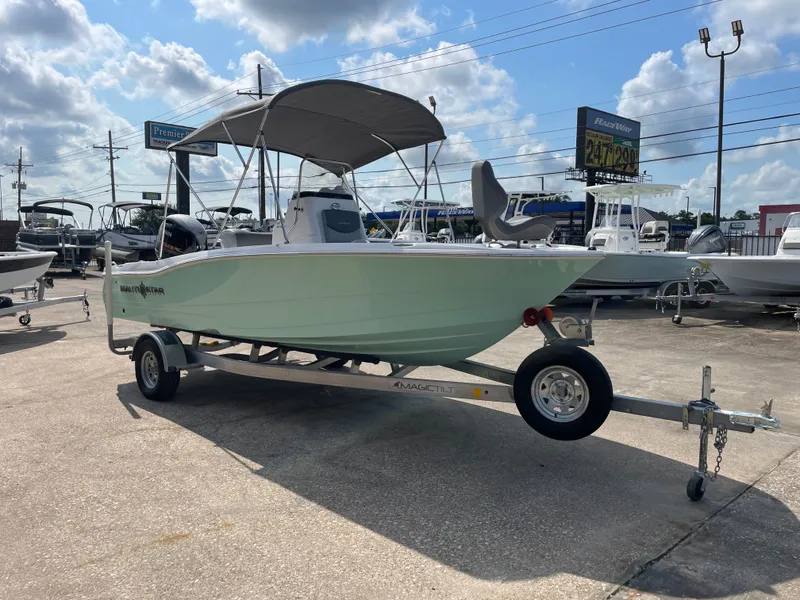 Slide: The Image of 2024 NauticStar 191H boat on trailer, displayed outdoors under a cloudy sky. - 6
