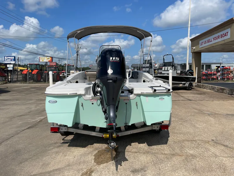Slide: The Image of 2024 NauticStar 191H boat with outboard motor, parked outdoors under a blue sky. - 8