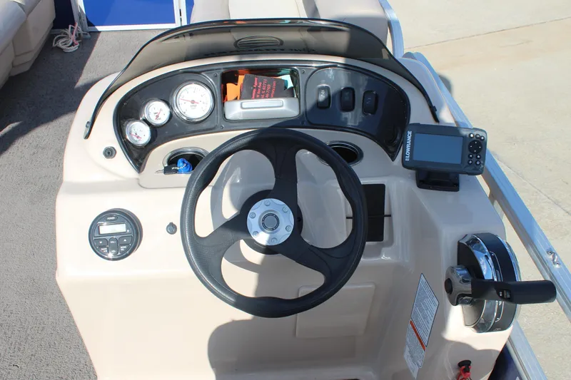 Slide: The Image of 2016 Sun Tracker Party Barge 16 DLX dashboard with steering wheel and navigation controls. - 13