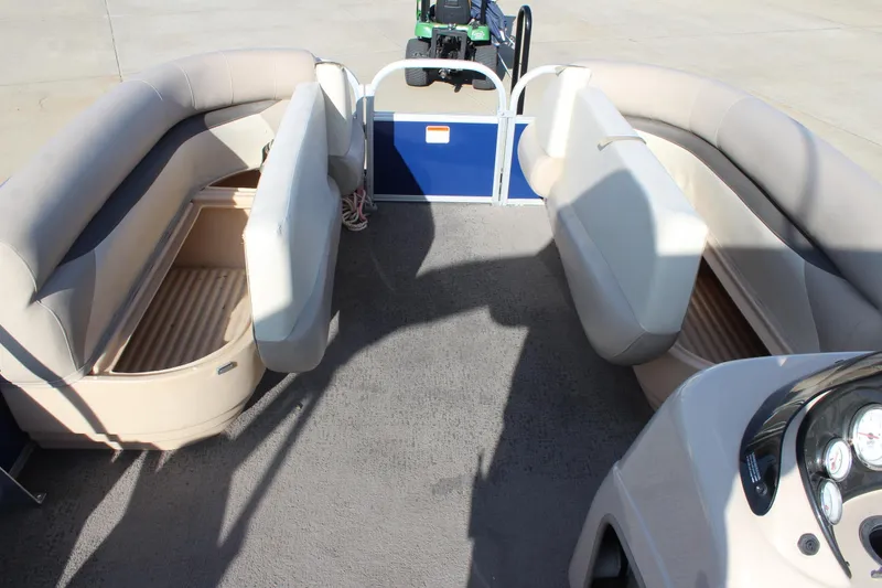 Slide: The Image of 2016 Sun Tracker Party Barge 16 DLX interior with beige seating and storage compartments. - 21