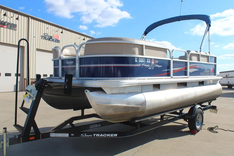 Slide: The Image of 2016 Sun Tracker Party Barge 16 DLX pontoon boat on trailer, outdoor setting. - 3