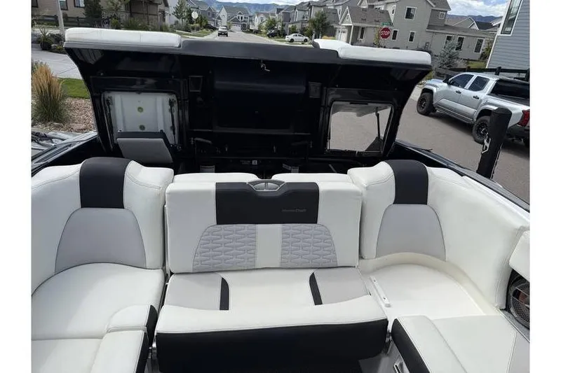 Slide: The Image of 2021 MasterCraft X24 boat interior with luxurious seating and open storage compartment. - 4