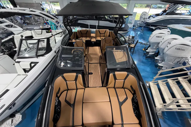 Slide: The Image of 2026 Yamaha Boats 255 XD interior with tan seating, showcased in a showroom. - 10