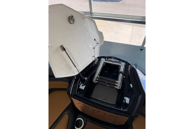 Slide: The Image of Open hatch of 2026 Yamaha Boats 255 XD, showcasing interior storage and ladder. - 26