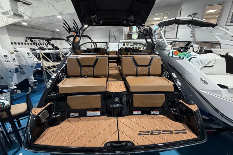 Slide: The Image of 2026 Yamaha Boats 255 XD with luxurious seating and sleek design in showroom. - 7