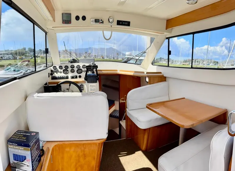 Slide: The Image of Interior of a 2004 Rodman 800 boat with helm and seating area. - 13