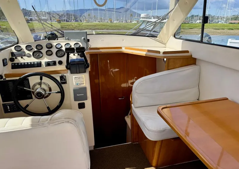 Slide: The Image of Interior of a 2004 Rodman 800 boat with steering wheel and seating area. - 15