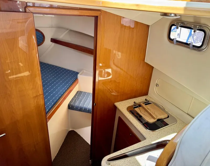 Slide: The Image of 2004 Rodman 800 boat interior with cozy cabin and compact kitchenette. - 19