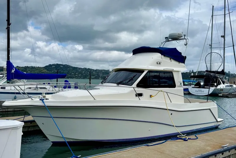 Slide: The Image of 2004 Rodman 800 boat docked at marina under cloudy sky. - 2