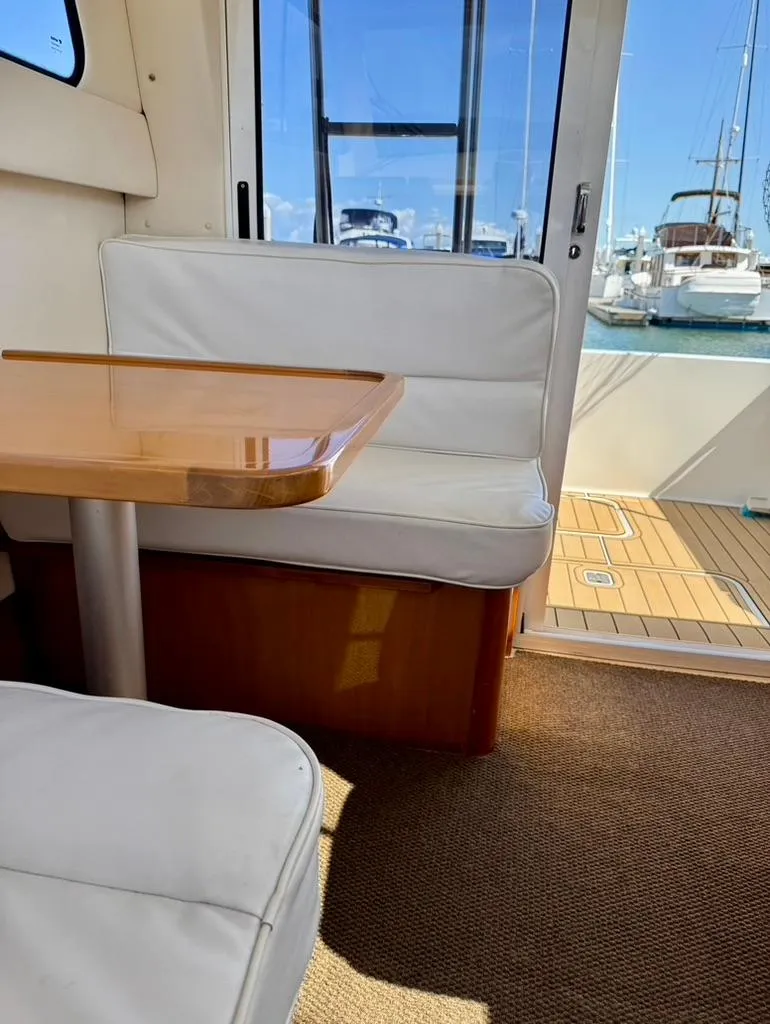 Slide: The Image of Interior of 2004 Rodman 800 boat with white seating and wooden table. - 21