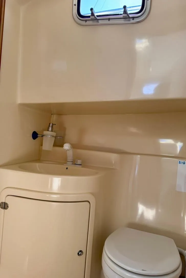 Slide: The Image of Compact bathroom in a 2004 Rodman 800 boat with sink and toilet. - 26