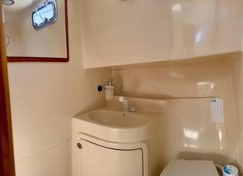 Slide: The Image of Compact bathroom in 2004 Rodman 800 boat with sink, mirror, and porthole. - 27