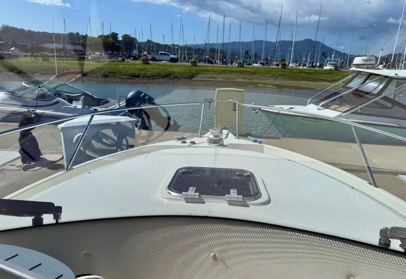 Slide: The Image of Front view of a 2004 Rodman 800 boat docked at a marina. - 7