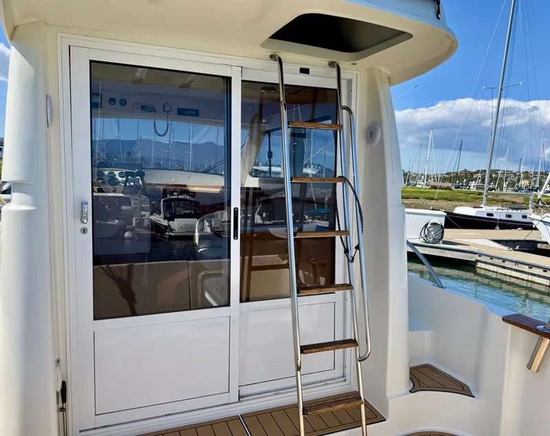 Slide: The Image of Rodman 800 boat, 2004 model, with sliding glass doors and ladder, docked at marina. - 8