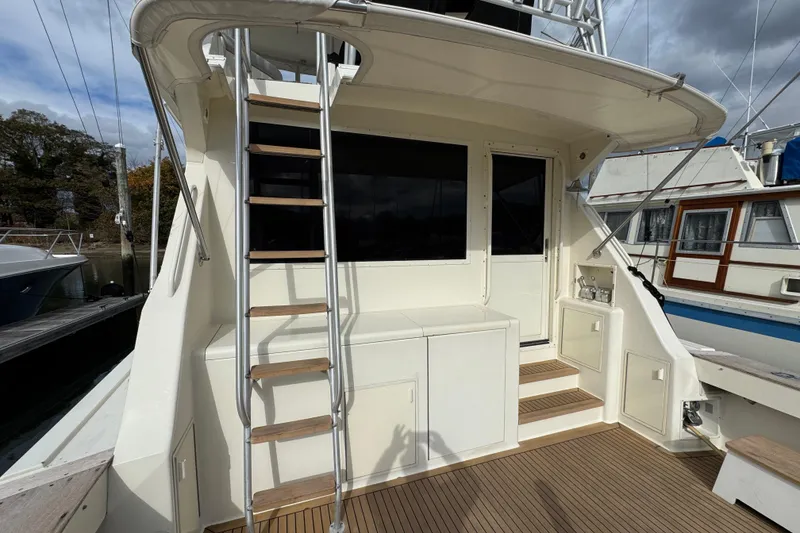 Slide: The Image of 1991 Viking 53 Convertible yacht with ladder and deck, docked at marina. - 10