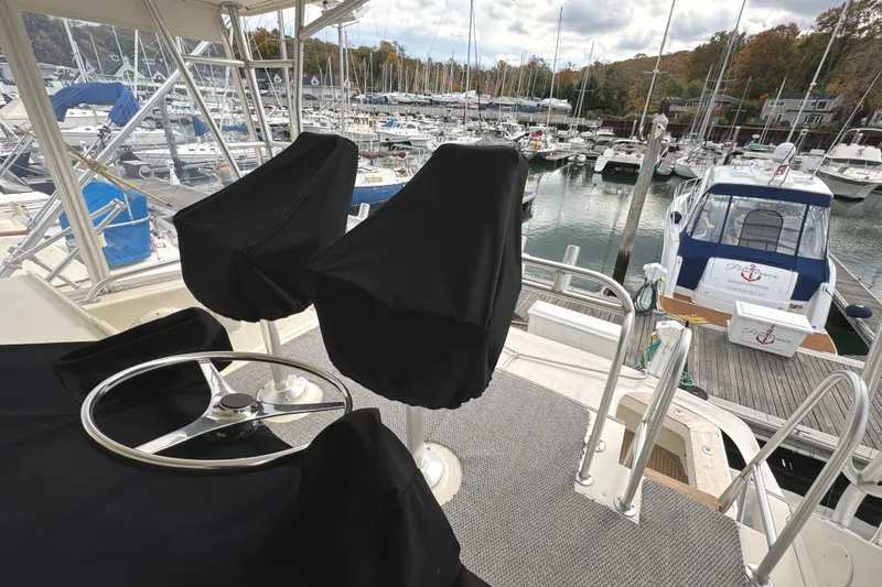 Slide: The Image of 1991 Viking 53 Convertible yacht helm with covered controls at marina. - 14