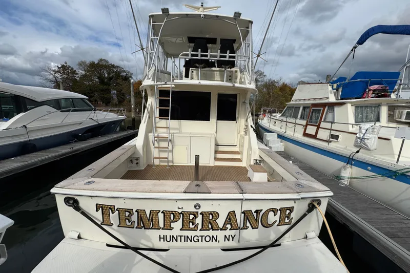 Slide: The Image of 1991 Viking 53 Convertible yacht docked at marina under cloudy sky. - 3