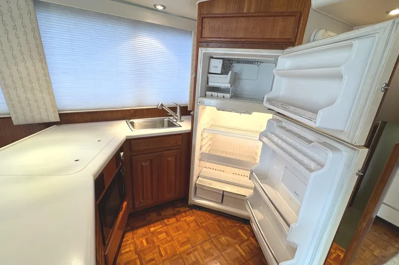 Slide: The Image of Luxurious interior of a 1991 Viking 53 Convertible yacht with leather seating and wooden table. - 35