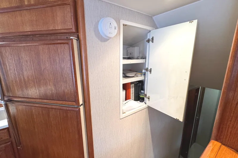 Slide: The Image of 1991 Viking 53 Convertible yacht kitchen with open fridge, sink, and wooden cabinets. - 38