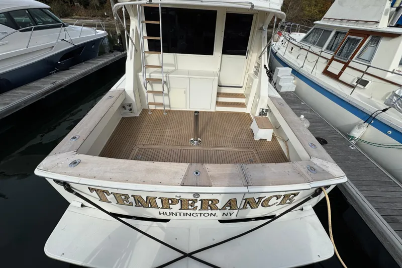 Slide: The Image of 1991 Viking 53 Convertible yacht docked at marina under cloudy sky. - 4