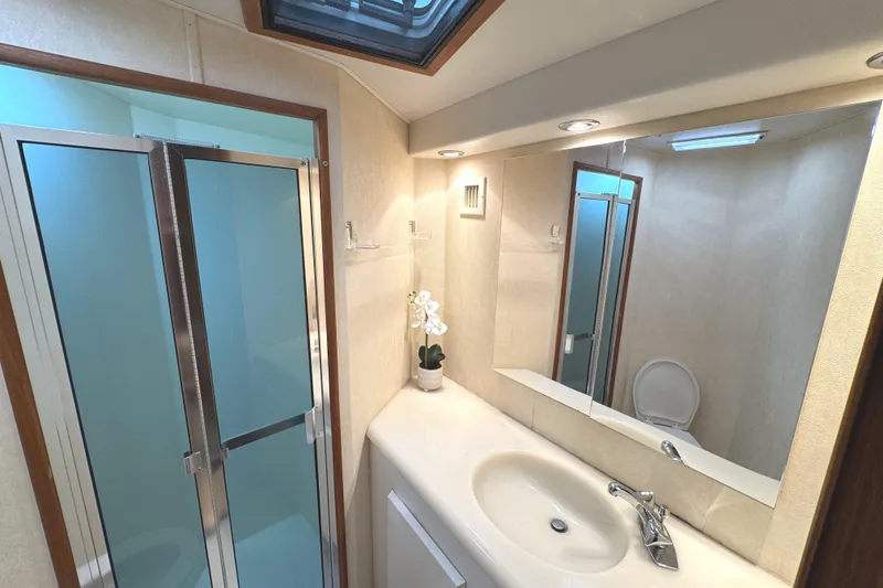 Slide: The Image of Luxurious bedroom interior of 1991 Viking 53 Convertible yacht with wood paneling and cozy bedding. - 45