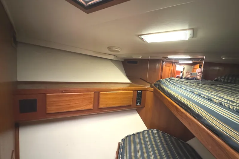 Slide: The Image of 1991 Viking 53 Convertible yacht interior with wooden bunk beds and striped bedding. - 55